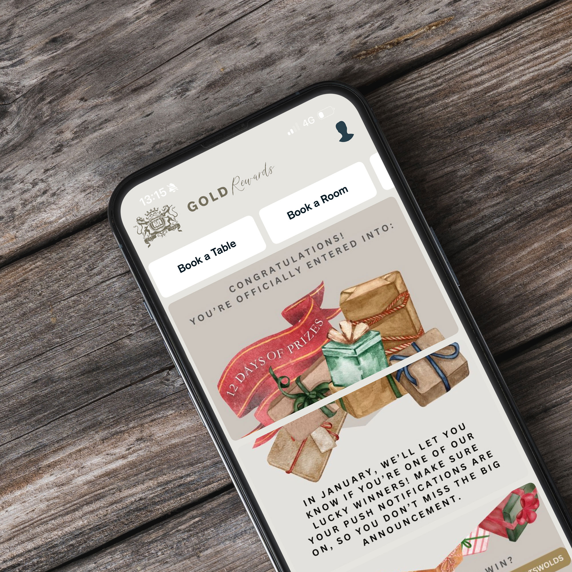 Smartphone on wooden surface displaying a congratulatory message for a prize entry, featuring images of wrapped gift boxes. - Wild Thyme & Honey Hotel in the Cotswolds